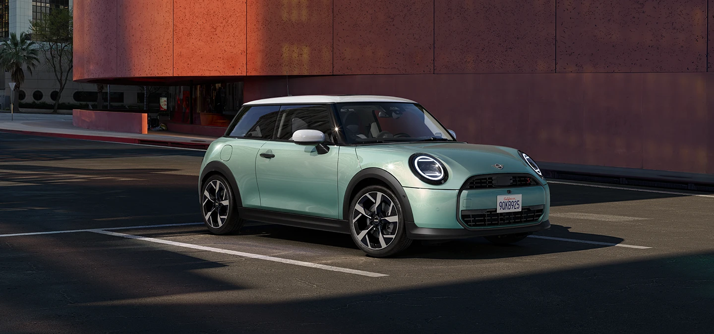 Seitliche Frontansicht des MINI Cooper in Ocean Wave Green mit weißem Dach.