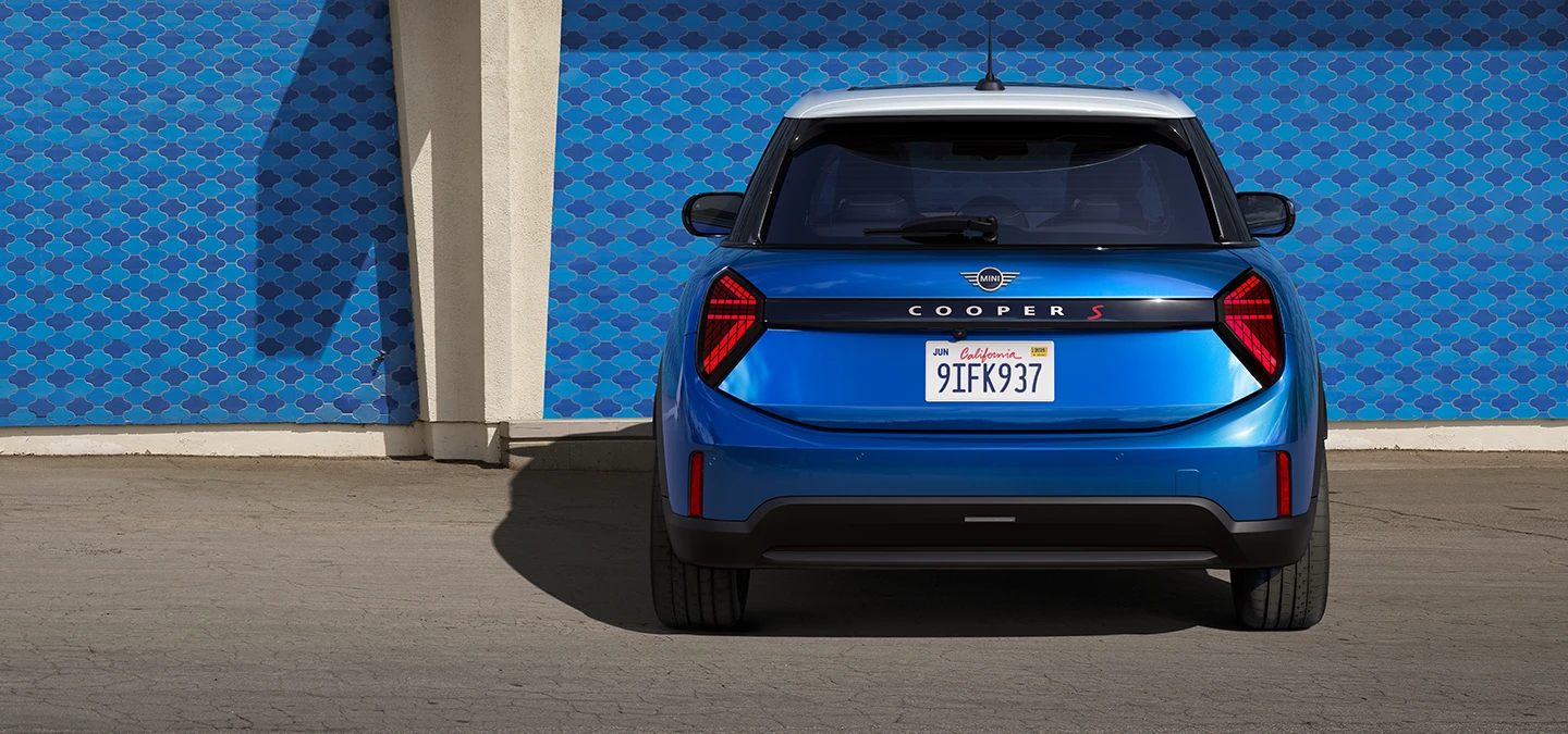 Heckansicht eines MINI Cooper 5-Türer in Icy Sunshine Blue mit Dach in Multitone Blue.