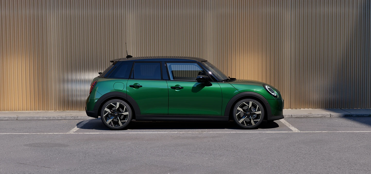 Seitenansicht eines geparkten MINI Cooper 5-Türer in British Racing Green und Dach in Schwarz.