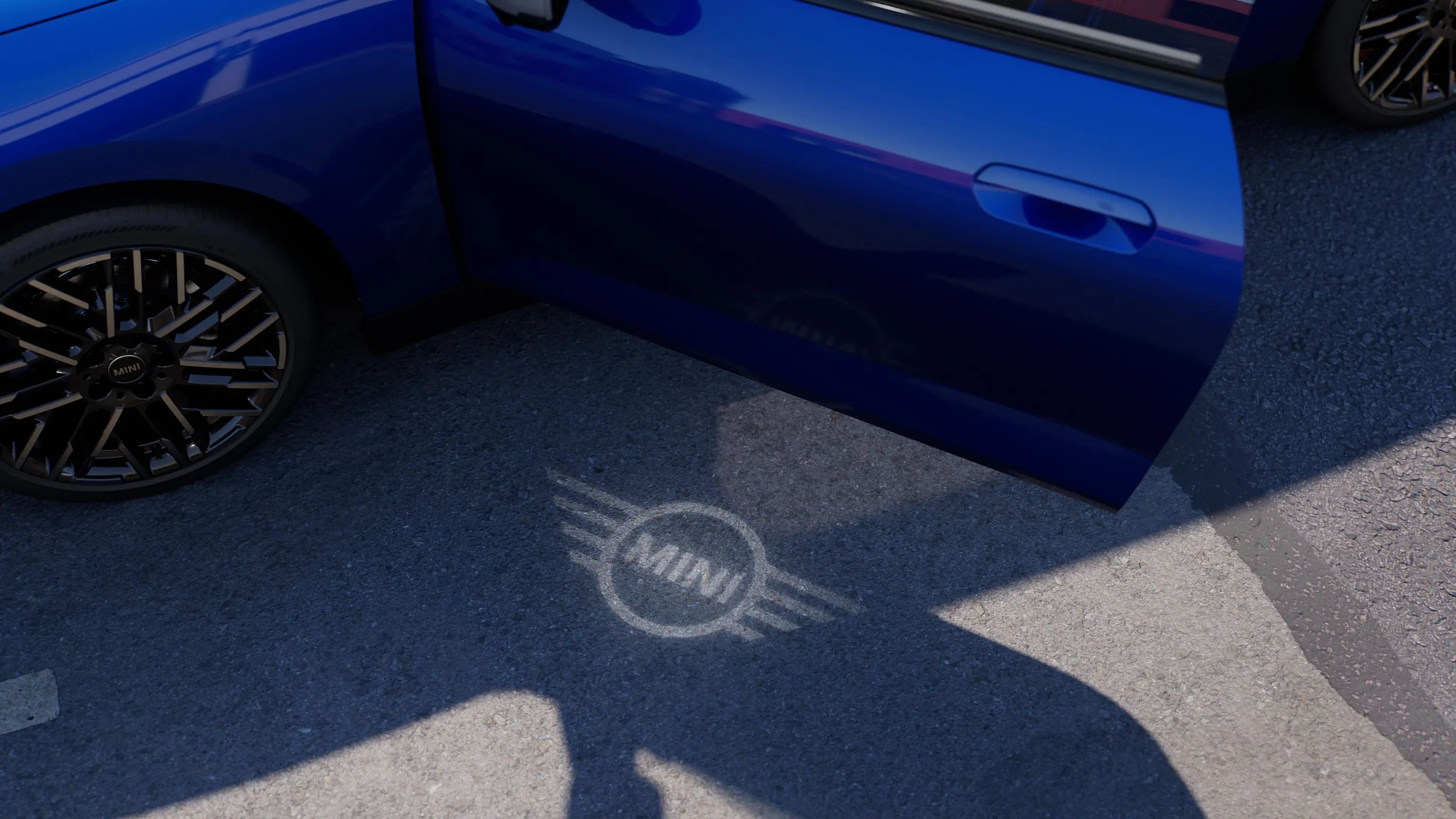 Außenansicht des vollelektrischen MINI Cooper mit geöffneter Tür und Begrüßungslicht mit MINI Logo auf dem Boden