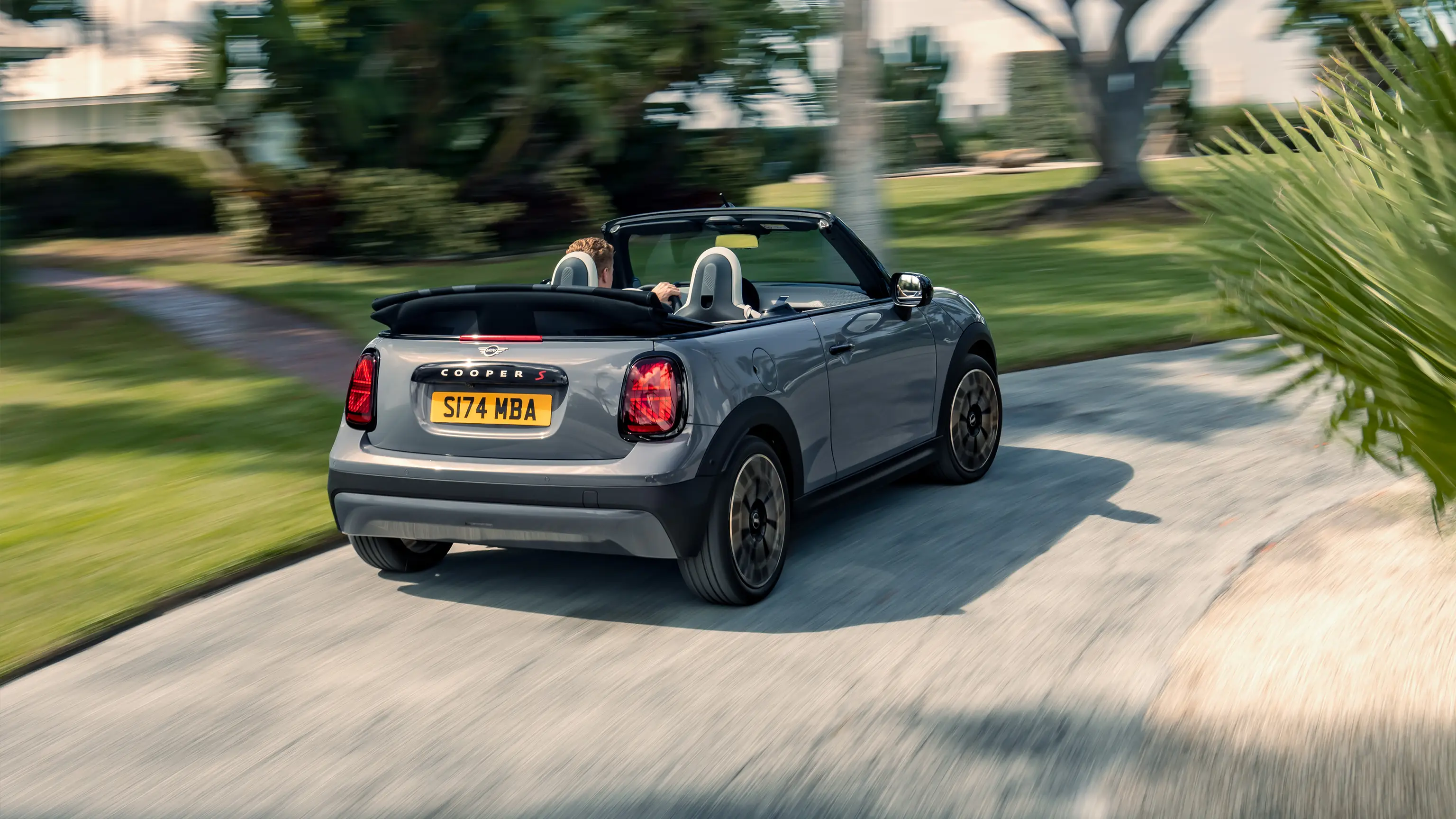 Heckansicht eines fahrenden MINI Cooper Cabrio in Copper Grey 