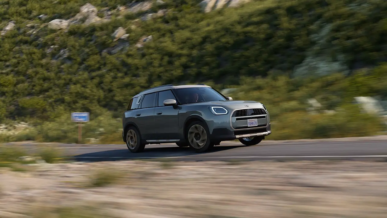 Ansicht des MINI Countryman Favoured Trim in Smokey Green beim Fahren abseits der Straße