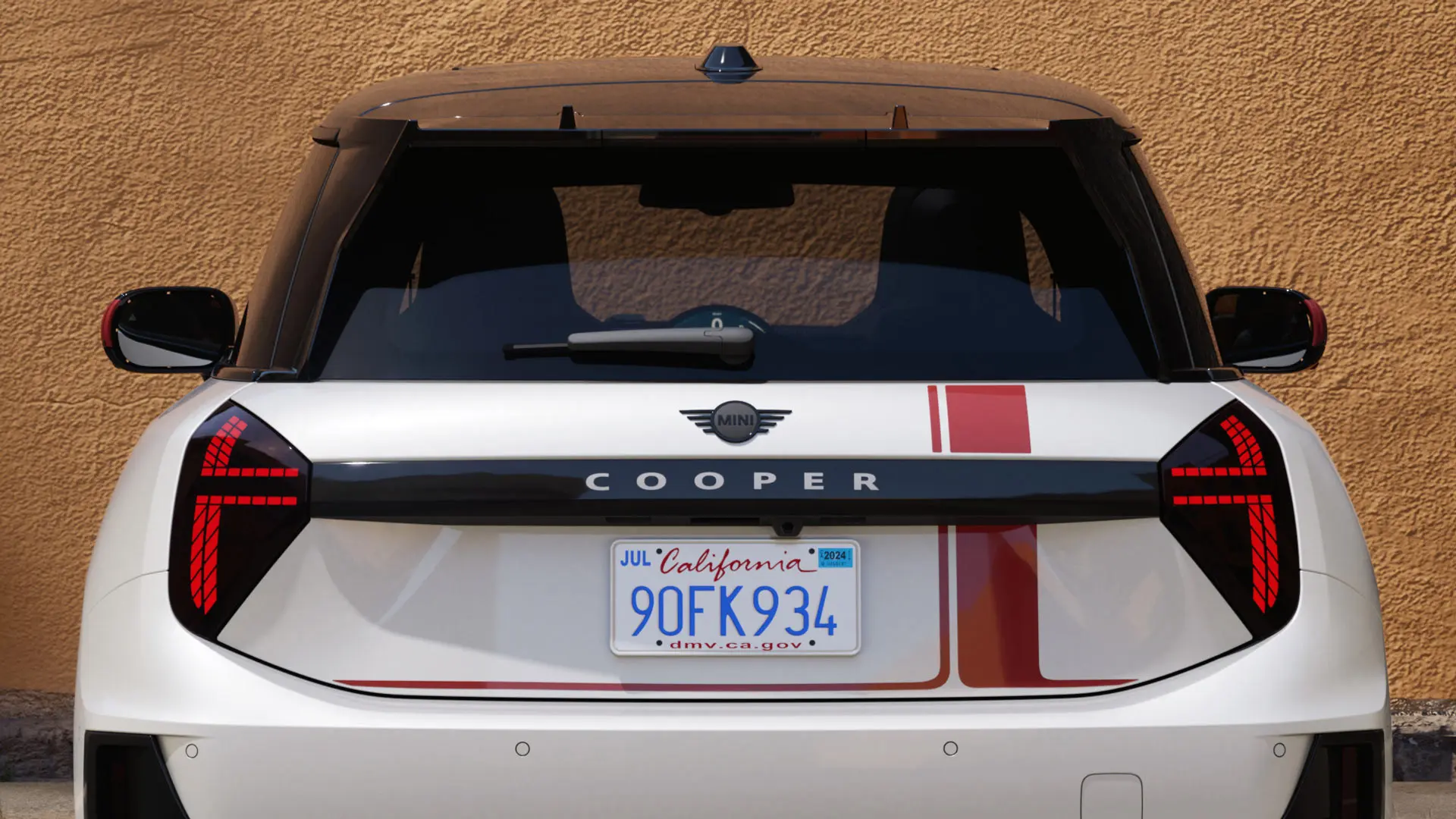 MINI Cooper mit MINI John Cooper Works Aufklebern in Chili Red in der Heckansicht. 