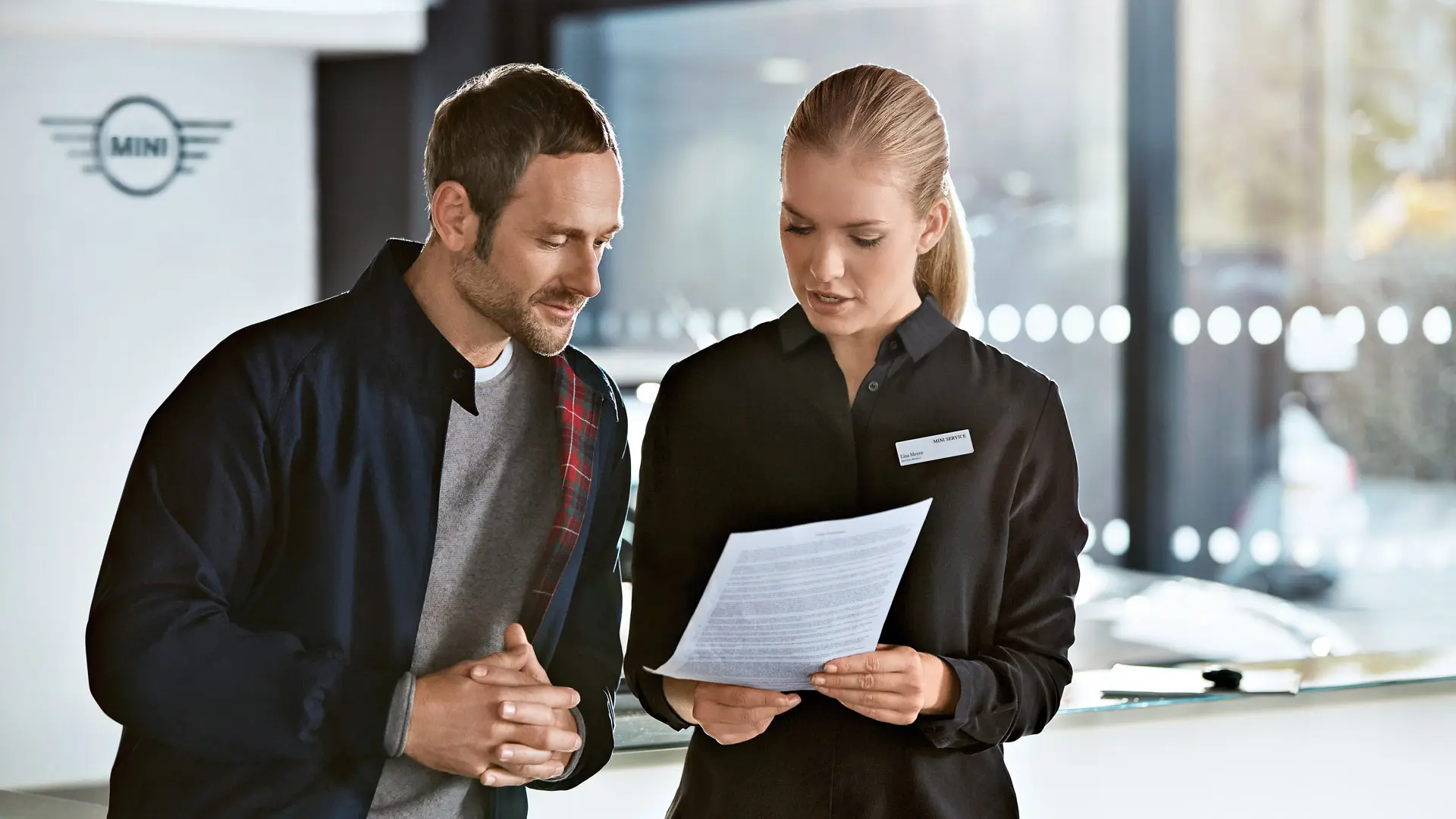 Ein MINI Serviceberater berät einen Kunden im MINI Center über Servicepläne.