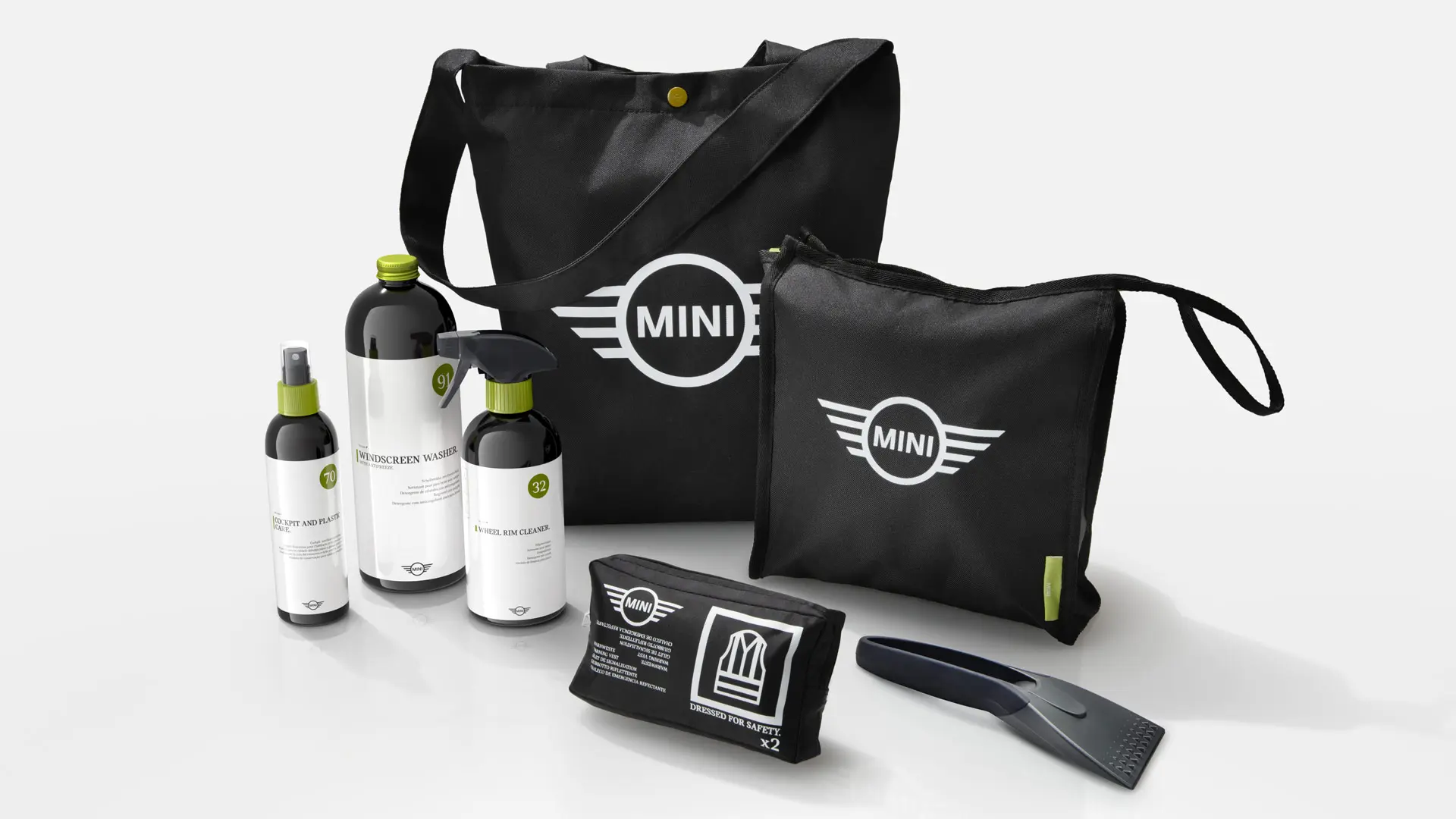 Eine Auswahl an Reinigungsprodukten aus dem MINI Car Care Set in schwarzen Taschen mit MINI Logo.