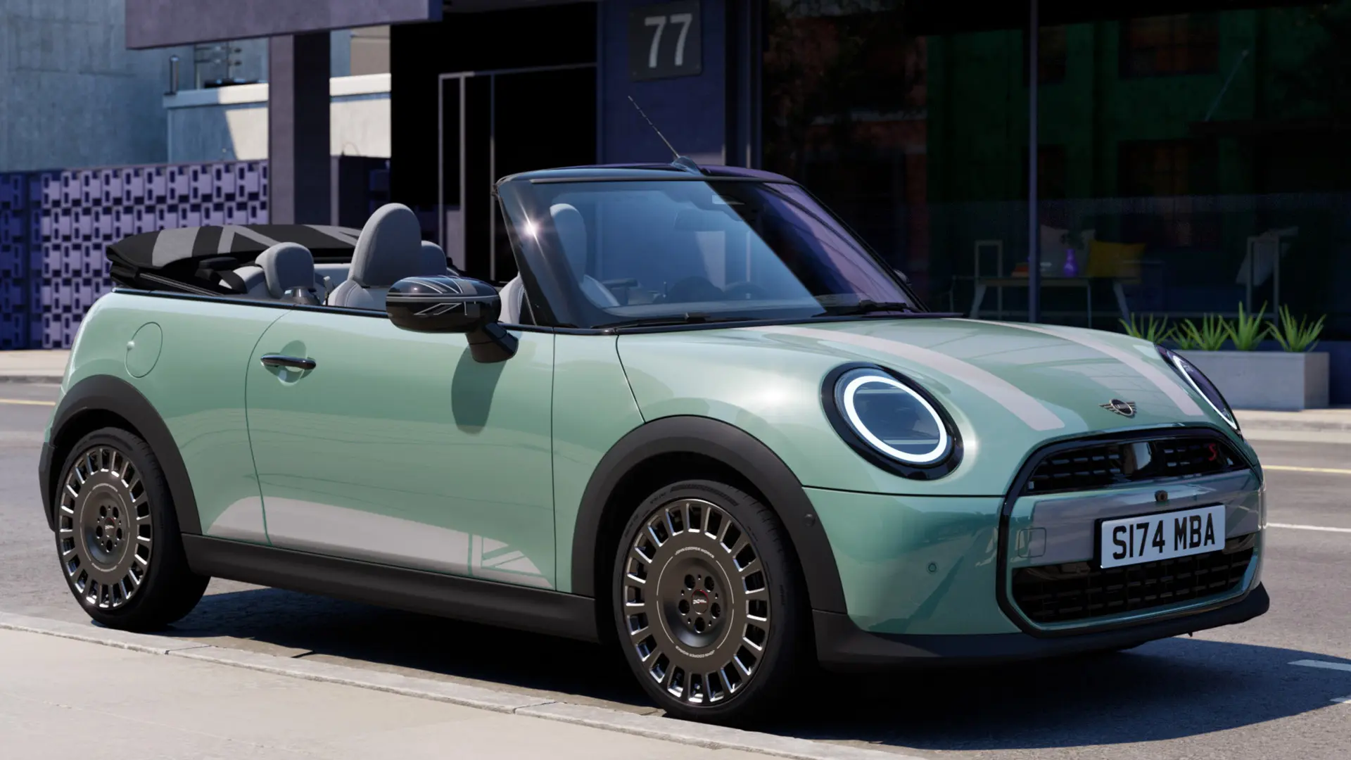 Vorderansicht eines MINI Cabrio in Ocean Wave Green mit MINI Motorhauben-Folierung Heritage in Weiß. 