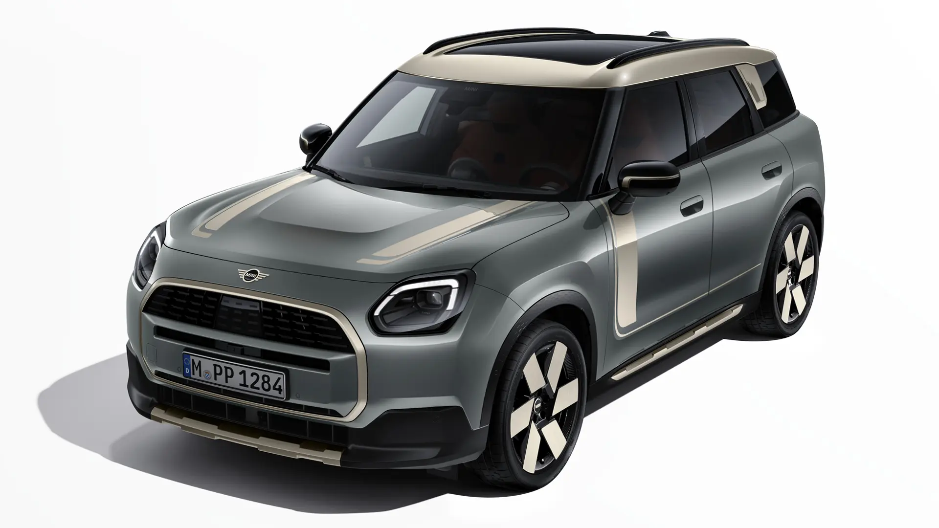 Dreiviertelansicht eines MINI Countryman Electric in Smokey Green mit MINI Favoured-Klebefolien in Vibrant Silver.