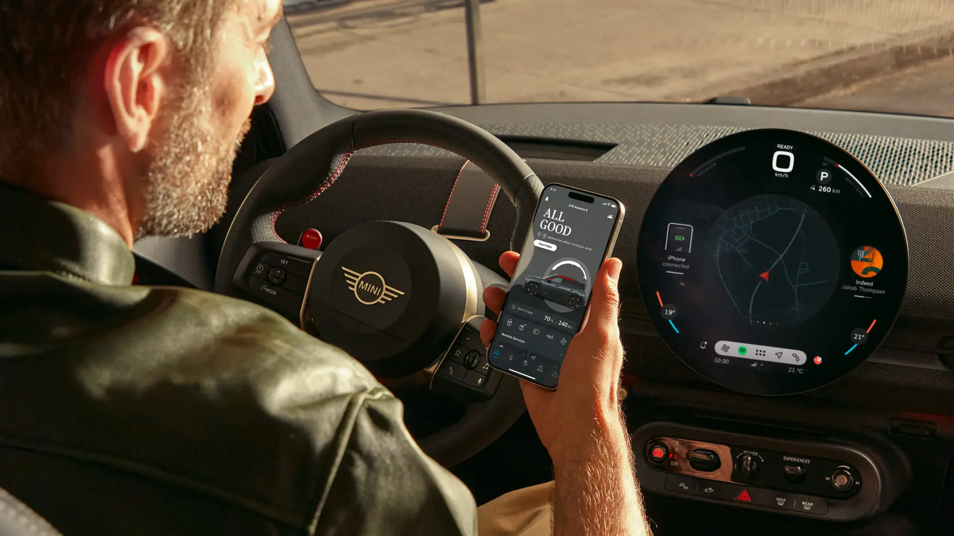 Ein MINI Fahrer nutzt die MINI App auf seinem Handy für die Navigation.