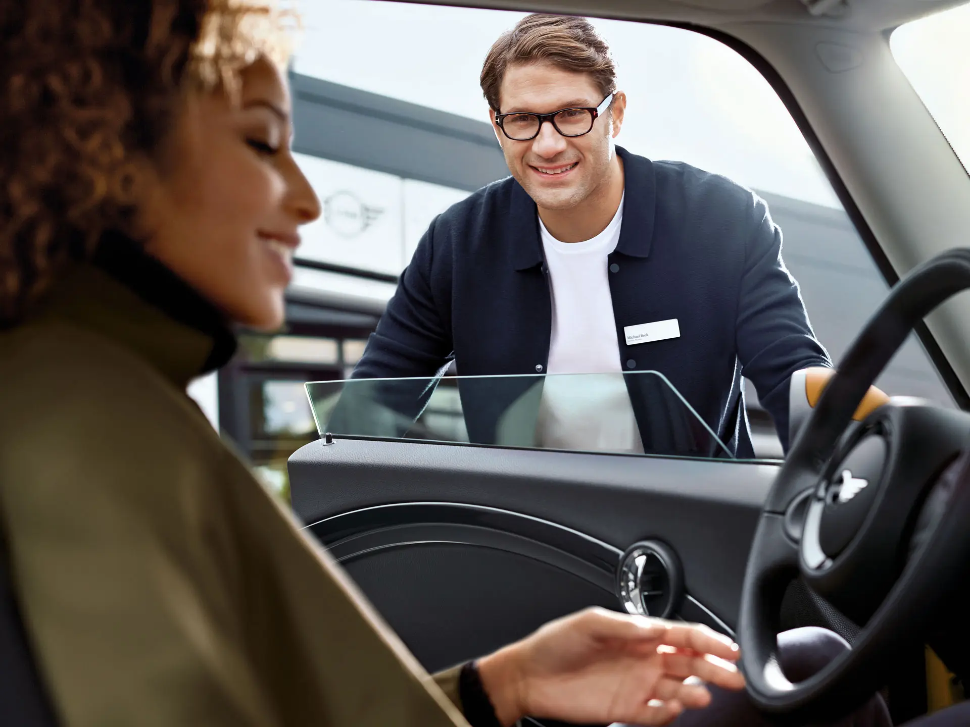 MINI Mitarbeiter begrüßt Service Kunden.