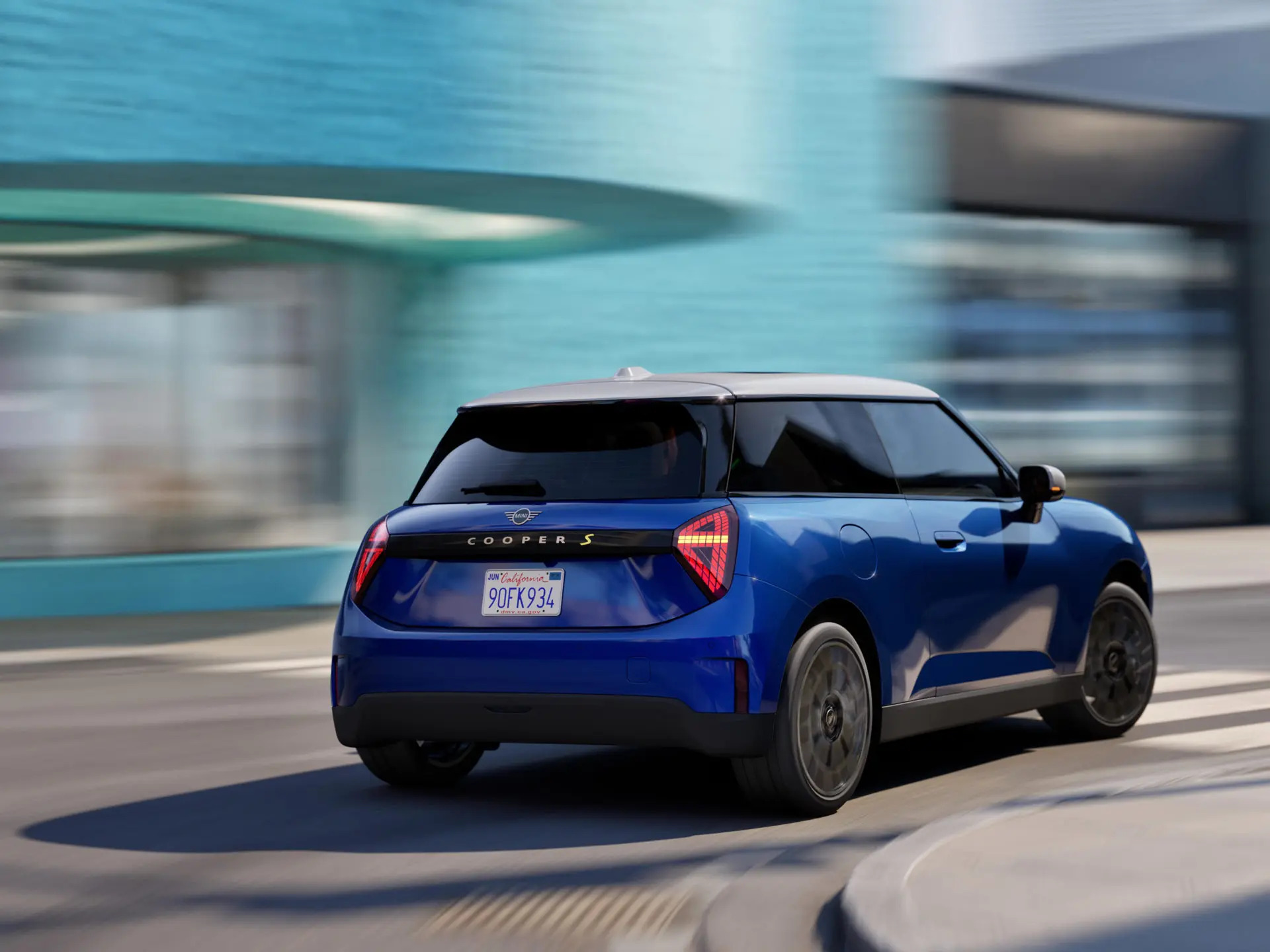 Ein MINI Cooper fährt dynamisch um die Kurve. 