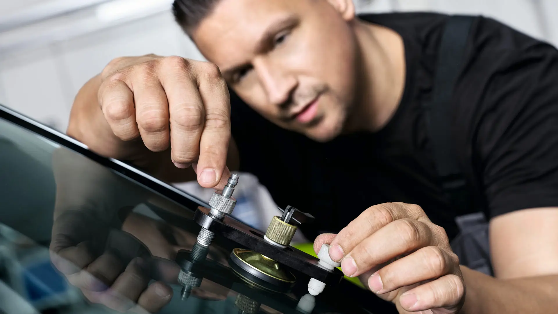 MINI Mitarbeiter repariert Windschutzscheibe.
