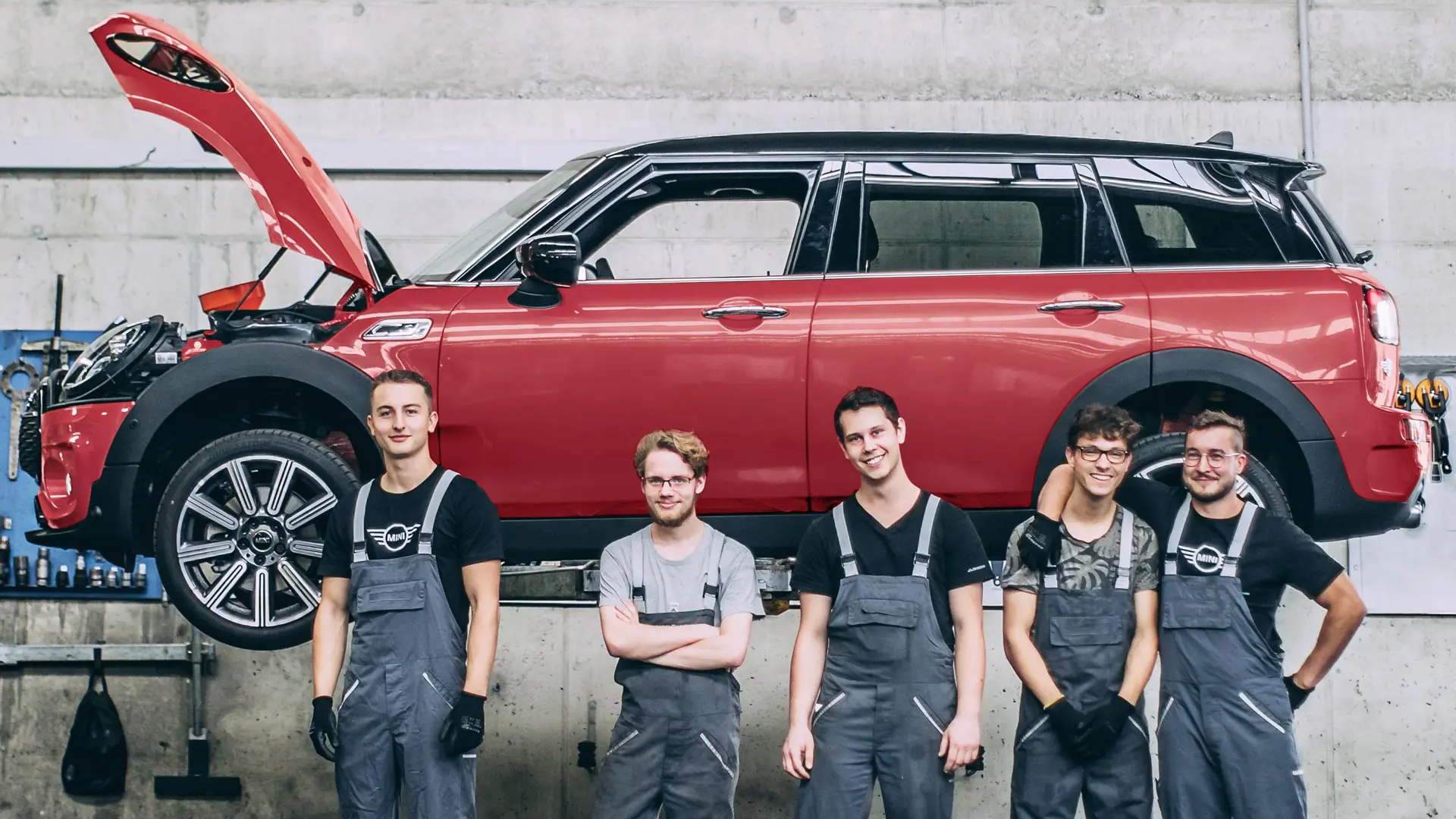 MINI Service Mitarbeiter vor einem MINI Countryman auf einer Hebebühne.