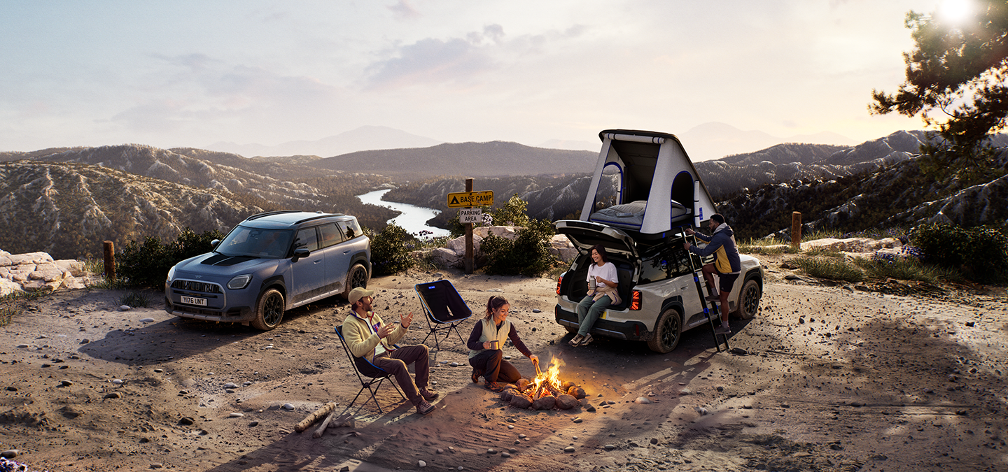Bild von zwei MINI Countryman Untamed Edition-Fahrzeugen auf einem Berg bei Sonnenuntergang.