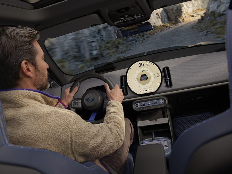 Bild von zwei Personen, die im MINI Countryman Untamed Edition mit aktiviertem Trail-Modus fahren.