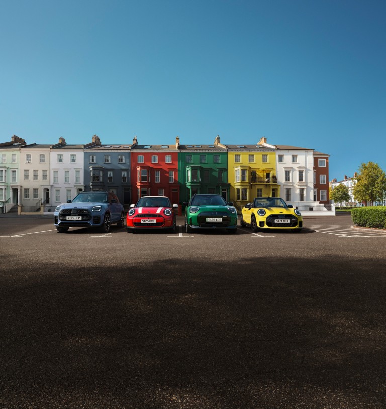 Drei MINI Fahrzeuge stehen nebeneinander auf einer verschneiten Fläche vor winterlicher Berglandschaft.