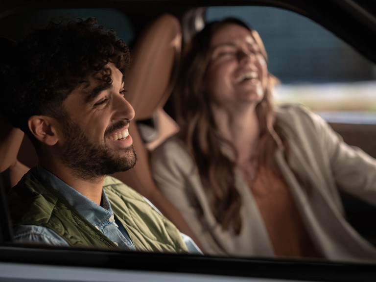 Zwei Menschen lachen fröhlich in einem MINI