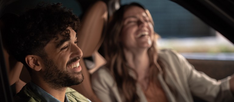 Zwei Menschen lachen fröhlich in einem MINI