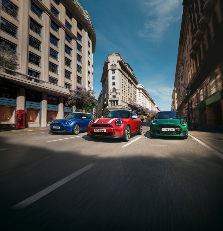 Drei MINI Fahrzeuge stehen nebeneinander auf einer verschneiten Fläche vor winterlicher Berglandschaft.