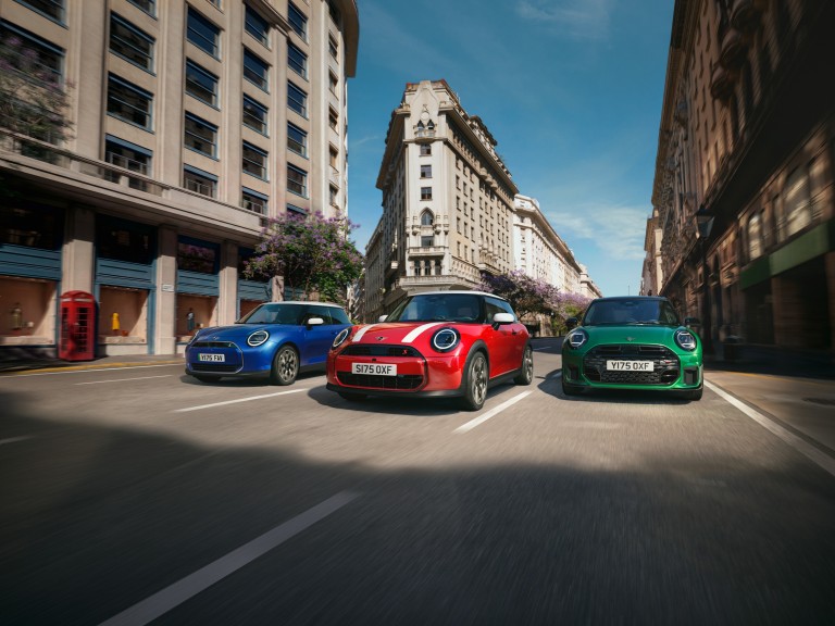 Drei MINI Fahrzeuge stehen nebeneinander auf einer verschneiten Fläche vor winterlicher Berglandschaft.