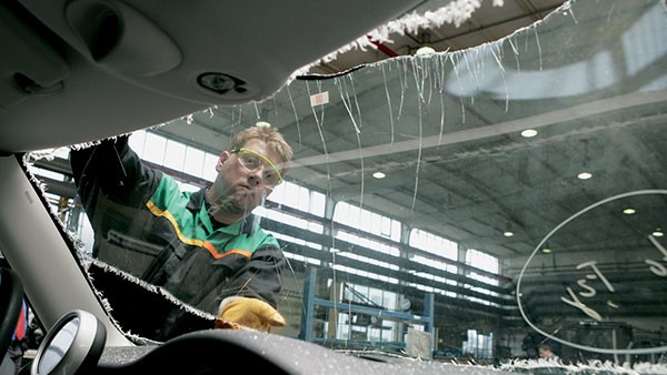 Handwerker baut Frontscheibe an den MINI ein.